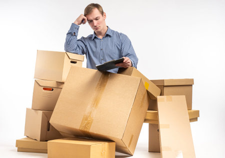 Problems in business. A businessman in the middle of fallen cardboard boxes. Sad small business...
