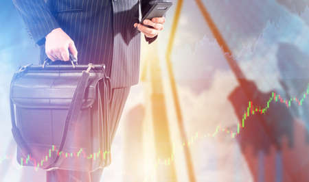 Illustration on topic of trading. Trader with a briefcase on the background of skyscrapers. Trader in a business suit. Concept - he is engaged in trading via a smartphone. Investments over phone.の写真素材