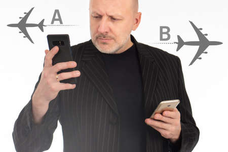 Buying air tickets through application concept. Airplane silhouettes as a metaphor for buying air tickets. Application for selling plane tickets. Businessman with smartphones on a white background.の写真素材