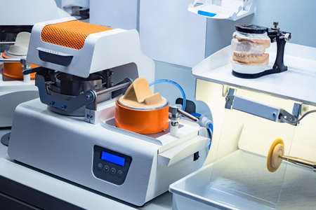 Workplace with equipment dental technician. Equipment production of dental prostheses. Prosthetist-dentist work equipment. Prosthetist devices on laboratory table. Grinding machine of denturesの写真素材