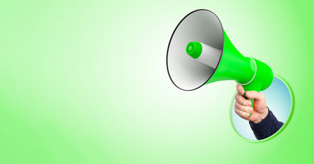 Loudspeaker in man's hand. Loudspeaker is metaphor for advertising and marketing. Place for text on...