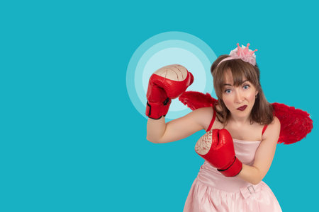 Princess with boxing gloves. Woman boxer looking at camera. Girl princess on a turquoise background....