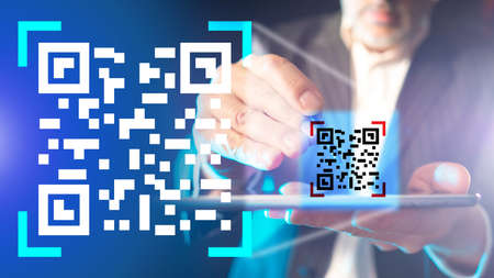 Scan QR code using electronic tablet. Man scan the QR code on mobile phone or tablet. Electronic, digital technologies, barcode. Payment by Qr code, electronic wallet, cashless technology.の写真素材