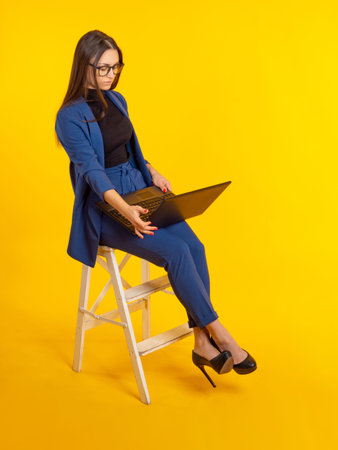 Stylish businesswoman with laptop. Woman is dressed in modern business attire. Attractive girl with...