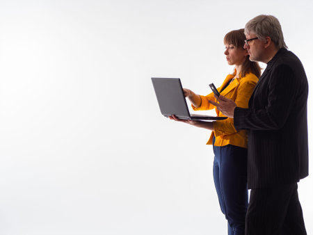 Two business people are looking into laptop. Business partnership on white background. Man and woman...