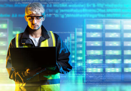 Data Engineering. Data processing specialist. Man with laptop on server background. Gray-haired software engineer. He is engaged in information processing. Server room and code behind it. Art blurredの写真素材