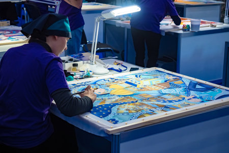 Work on art order. Painting. Factory for the manufacture of handmade paintings. Girls work as designers at the enterprise. Women draw with gouache. Russia. Saint Petersburg. 11.29.2018のeditorial素材