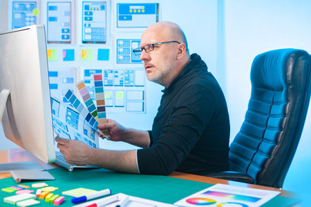 UX and UI designer. A man holds a color palette in his hands. The choice of color for the mobile...