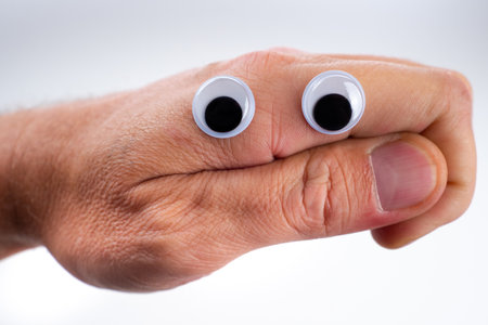 Emoji. A face made from a hand shows doubt. Emoji icon doubter. A hand with plastic eyes shows emotions. The person expresses doubt. Doubting face. Smiley - person without emotions. Smileys Neutralityの写真素材