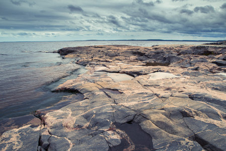 Russia. Karelia. Ladoga Lake. Rocks on the coast. The stone shore of Lake Ladoga. Water. Northern...