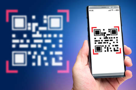 Mobile QR code. Smartphone in hand of man. Scan QR key. Concept of authorization using bar code. Metaphor of identification via QR link. Quick Response code. Dot matrix barcode in phoneの写真素材