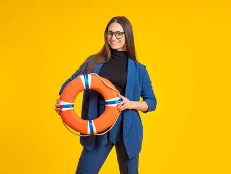 Woman with lifebuoy. Business concept. Businesswoman demonstrates lifebuoy. Metaphor of business rescue or insurance. Insurance services for companies. Providing assistance to entrepreneurs.の写真素材
