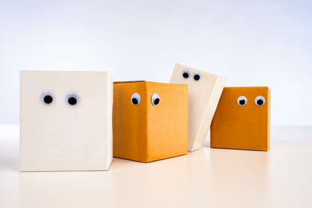 Emoji out of the box. Parcels with eyes. The queue of parcels to send. Paper boxes look down. Eyes are glued on a cardboard box. cases for moving stand in line. Boxes saw something below Loading queueの写真素材