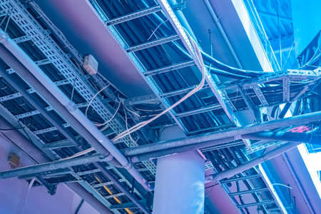 Electrical communications at the enterprise. Engineering infrastructure. A lot of wires under the ceiling. Network engineering. Electricity in the enterprise. Electricity in an industrial building.の写真素材