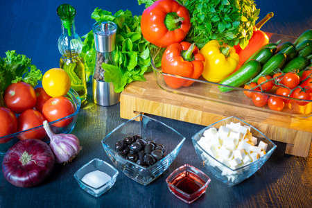 Greek salad. Learning how to make a salad. Illustration for a recipe book. Salad dressing. Vegetables ready to cook side dish. Black olives and cheese. Onions, garlic, paprika, tomatoes, lemon.の写真素材