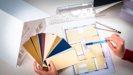 Choice of color of walls in the house. Interior Design. Work of interior designer. Designer chooses a color for walls. Interior designer with a palette in his hands. Choice of finishing materialsの写真素材