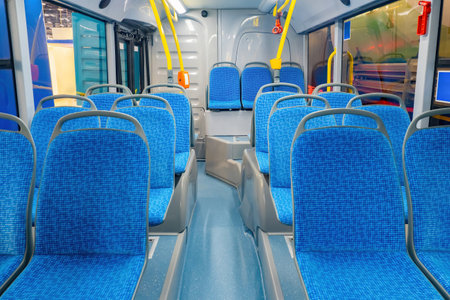 interior of bus. Concept - municipal transport. Seats on city bus or tram. And public transport equipment. Empty bus with blue seats. Public transport with yellow handrails. Trolleybus inside viewの写真素材