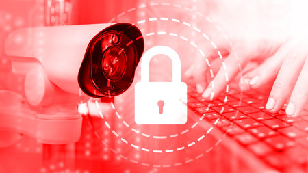 CCTV camera on red background. Hands on keyboard near camera. Data security video surveillance...