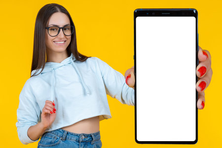 Happy woman with phone. Big phone. Student demonstrates empty gadget. Mobile phone for your...