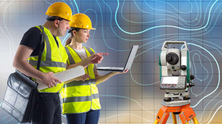 Surveyors are working. Workers are engaged in topographic surveys. Creation of geodetic images. Two surveyors with laptop in their hands. Topographic map in background. Optical theodelite.の写真素材