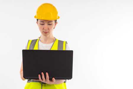 Woman builder with laptop. Girl engineer. Builder on white background. Engineer is designing...