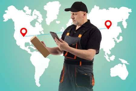Courier delivery. Courier on background of world map. Delivery man with box. International courier delivery. Sending goods from one country to another. Concept is an international logistic service.の写真素材