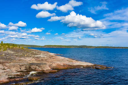 Karelia. Russia. The nature of Russia. Lakes of Karelia. Ladoga. Landscapes of Karelia. Rocky coast. Waves splash on the rocks. Northern Nature of Russia. Ladoga on a summer day. Russian Forest.の写真素材