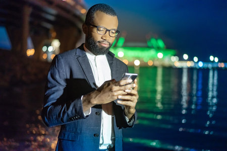 Black man with a smartphone. The guy in the night city. The guy with the cellphone. A man calls a...