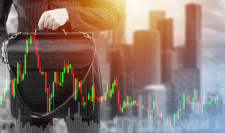 Male investor. Investor with business portfolio. Downtown with skyscrapers in background. Charts represent trading or investing. Portrait of businessman trader without face. Selective focusing.の写真素材