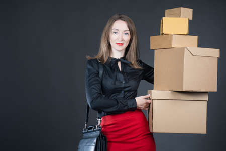 Woman with cardboard boxes. Lot of boxes in hands of businesswoman. Businesswoman posing with boxes. Business woman portrait. Parcels in hands of business woman. Concept - female store owner.の写真素材