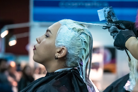 Beauty saloon. Woman dye her hair at the hairdresser. Woman in a beauty salon. Girl during hair dyeing. To a dark-haired girl, their hair color changes. California. USA. 02.24.2019のeditorial素材