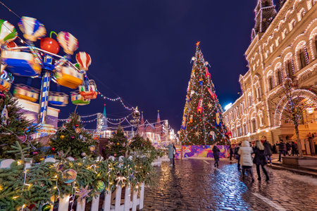 Moscow. Russia. Christmas fun in the red square. New Year tree in center of Moscow. People walk near...