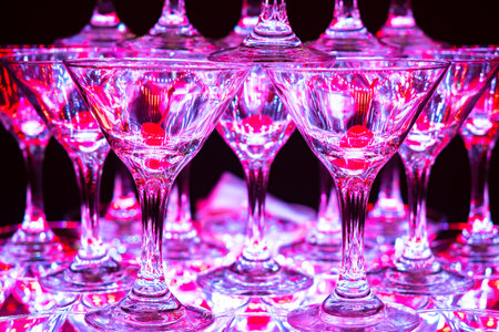 Glasses for a cocktail. Wineglass pyramid for cocktails. Cherry lies in the glasses. Glasses stand on top of each other. Concept - Organization of celebrations. Work as a bartender. Empty wineglass.の写真素材