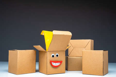 unpacking. Open box with a man's face. Joy of unpacking your purchase. Boxes are ready for unpacking. Concept - good packaging for the goods. Box with eyes and mouth. Shopping from the online storeの写真素材