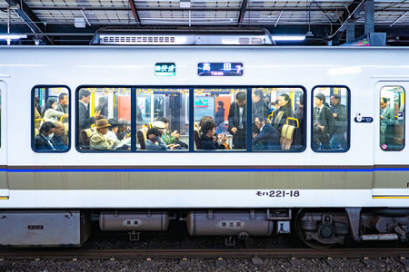 Japan Train in Tokyo. People can be seen through the train window. People in the intercity train in...