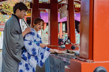 Japan. Geisha in Tokyo. A geisha washes his hands in front of the Asakusa Temple. Girl in japanese kimono. Japanese woman in national dress washes her hands. Man in Japanese Kimono. 09/11/2019のeditorial素材