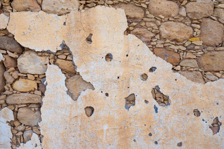 Texture of the stone. Background - a wall of solid stone. old stucco. stone wall. Paint drops off the wall. background from the building. Decrepit side. Construction of the last century.の写真素材