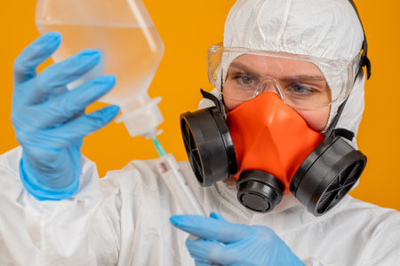 The face of an epidemiologist close up. A man in a respirator takes a sample of fluid. Epidemiologist at work. Laboratory assistant works in a respirator. Creating a cure for Chinese fever. 2019-nCoVの写真素材