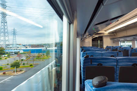 View from the train window. Interior of the Japanese train. Seats. Train to daybo island. Drive from Tokyo to Odaibo. empty wagon. Traveling around the cities of Japan. rail transportationの写真素材