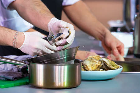 Cook. Culinaria. Work in the restaurant kitchen.Cook is drying lettuce leaves. Cook is preparing salad leaves. Recipes of restaurant dishes. cooking training. Man spread lettuce on cheeseclothの写真素材