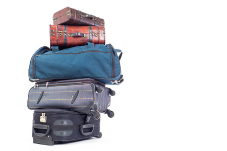 Many bags lie on top of each other. Large suitcases as a symbol of a long trip. Bags are ready for travel. Vintage suitcases next to modern bags. Baggage for travel on a white background.の写真素材