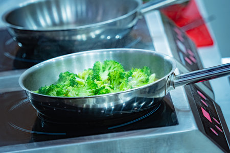 Broccoli in a pan. Cooking a side dish of broccoli. Roasting broccoli in butter. Cooking vegetable dishes. Stewing vegetables. Concept - a dish for a vegetarian. Restaurant for vegetarians.の写真素材