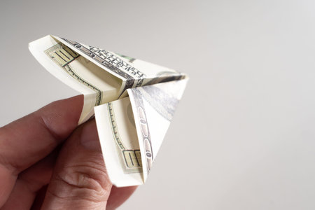 A man holds an airplane out of money. A man launches an airplane from a banknote. Concept -...