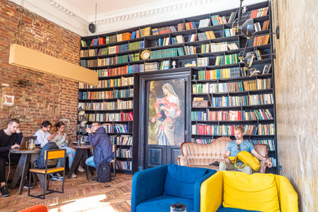 The interior of the restaurant is decorated with books. The wall of the restaurant is in the form of a shelf with books. People in a restaurant in St. Petersburg. Cafe in Russia. 04/07/2019のeditorial素材