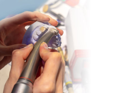 Dental technician during work. Making dentures close-up. A man processes a false jaw. The process of the orthodontist. Orthodontist grinds a prosthesis. Places for text. Career at the dental clinicの写真素材