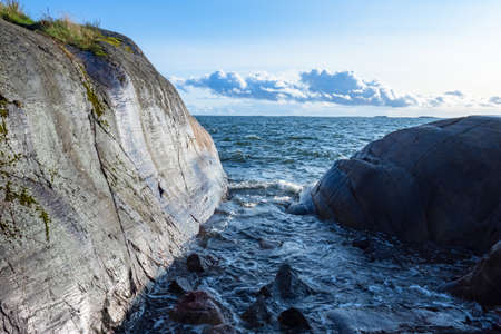 Nature of Finland. Waves whipping against the rocks. Rocky coast of Finland. northern nature. landscapes of northern nature. Sea rocks on the background of blue sky. Shore of the Baltic Sea.の写真素材