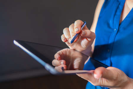 Woman with off-switched tablet. girl holding tablet in her hands. Business woman with electronic gadget. Concept of using tablet computers in business. business lady runs companies through gadgetの写真素材