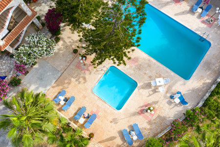 Cyprus. View of the pools with sun loungers on top. Resort in Cyprus. Area for spa treatments. Two pools near the house. Sun loungers by the pool. Recreation area near the house. Hotel with a poolのeditorial素材