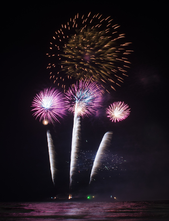 Fireworks light up the sky from boatの写真素材