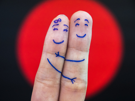 A happy couple in love with painted smiley and huggingの写真素材